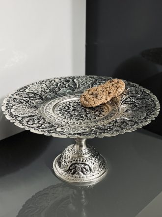 شیرینی‌خوری سایز ۳۰ با نقش گل و مرغ ممتاز، آبکاری نقره و تکنیک سیاه قلم، یکی از فاخرترین ظروف پذیرایی در سبک سنتی ایرانی است. این اثر هنری با فرم کلاسیک و ابعاد مناسب، انتخابی ایده‌آل برای پذیرایی از مهمانان در مناسبت‌های خاص، به‌ویژه با شیرینی‌های سنتی اصفهان است.