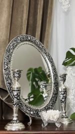 آینه و شمعدان قلمزنی گل شیرازی یکی از فاخرترین آثار صنایع دستی ایران است که جایگاه ویژه‌ای در سنت‌های عقد و عروسی دارد. این اثر نه تنها بخشی از زیبایی سفره عقد محسوب می‌شود، بلکه به عنوان هدیه‌ای ارزشمند در جهیزیه عروس نیز جایگاهی خاص دارد. استفاده از آینه و شمعدان در عروسی ریشه در فرهنگ ایرانی دارد.