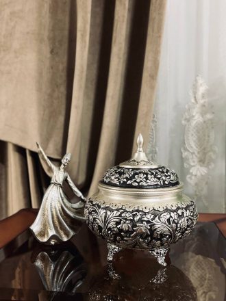 شکلات‌خوری ۴ پایه قلمزنی گل شیرازی (گل ترکی) این شکلات‌خوری فاخر با طراحی گل شیرازی (گل ترکی) و اجرای هنرمندانه‌ی قلمزنی سیاه‌قلم بر روی سطحی با آبکاری نقره، جلوه‌ای درخشان و ماندگار از صنایع دستی ایران است.