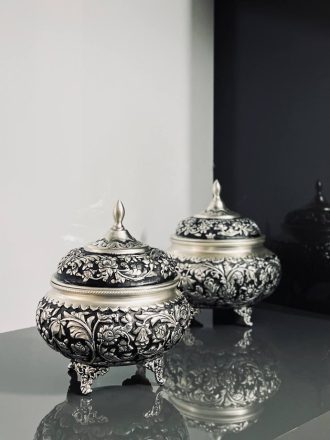 شکلات‌خوری ۴ پایه قلمزنی گل شیرازی (گل ترکی) این شکلات‌خوری فاخر با طراحی گل شیرازی (گل ترکی) و اجرای هنرمندانه‌ی قلمزنی سیاه‌قلم بر روی سطحی با آبکاری نقره، جلوه‌ای درخشان و ماندگار از صنایع دستی ایران است.