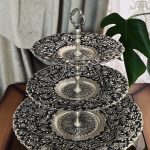 شیرینی‌خوری قلمزنی گل شیرازی (گل ترکی) | آبکاری نقره سیاه‌قلم این شیرینی‌خوری فاخر با نقش اصیل گل شیرازی (گل ترکی) و اجرای هنرمندانه‌ی قلمزنی سیاه‌قلم بر روی سطحی با آبکاری نقره، جلوه‌ای درخشان و ماندگار از صنایع دستی ایران است.