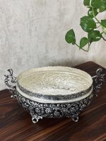 کشکول قلمزنی گل شیرازی (گل ترکی) | آبکاری نقره سیاه‌قلم این کشکول فاخر با نقش اصیل گل شیرازی (گل ترکی) و اجرای هنرمندانه‌ی قلمزنی سیاه‌قلم بر سطحی با آبکاری نقره، نمونه‌ای درخشان از صنایع دستی اصفهان است.