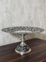 شیرینی‌خوری قلمزنی گل شیرازی (گل ترکی) | آبکاری نقره سیاه‌قلم این شیرینی‌خوری فاخر با نقش اصیل گل شیرازی (گل ترکی) و اجرای هنرمندانه‌ی قلمزنی سیاه‌قلم بر روی سطحی با آبکاری نقره، جلوه‌ای درخشان و ماندگار از صنایع دستی ایران است.