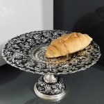 شیرینی‌خوری قلمزنی گل شیرازی (گل ترکی) | آبکاری نقره سیاه‌قلم این شیرینی‌خوری فاخر با نقش اصیل گل شیرازی (گل ترکی) و اجرای هنرمندانه‌ی قلمزنی سیاه‌قلم بر روی سطحی با آبکاری نقره، جلوه‌ای درخشان و ماندگار از صنایع دستی ایران است.