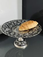 شیرینی‌خوری قلمزنی گل شیرازی (گل ترکی) | آبکاری نقره سیاه‌قلم این شیرینی‌خوری فاخر با نقش اصیل گل شیرازی (گل ترکی) و اجرای هنرمندانه‌ی قلمزنی سیاه‌قلم بر روی سطحی با آبکاری نقره، جلوه‌ای درخشان و ماندگار از صنایع دستی ایران است.